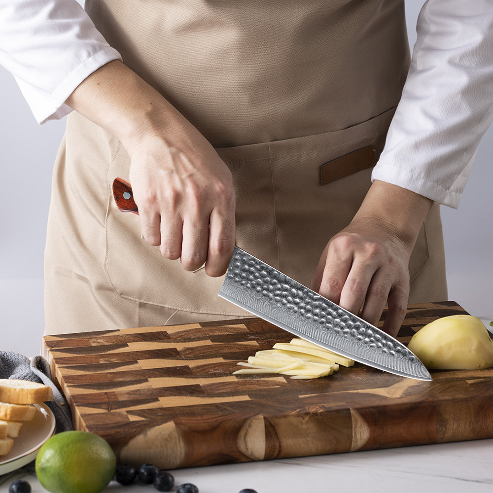 Person in a kitchen setting with a chef's knife and cutting board